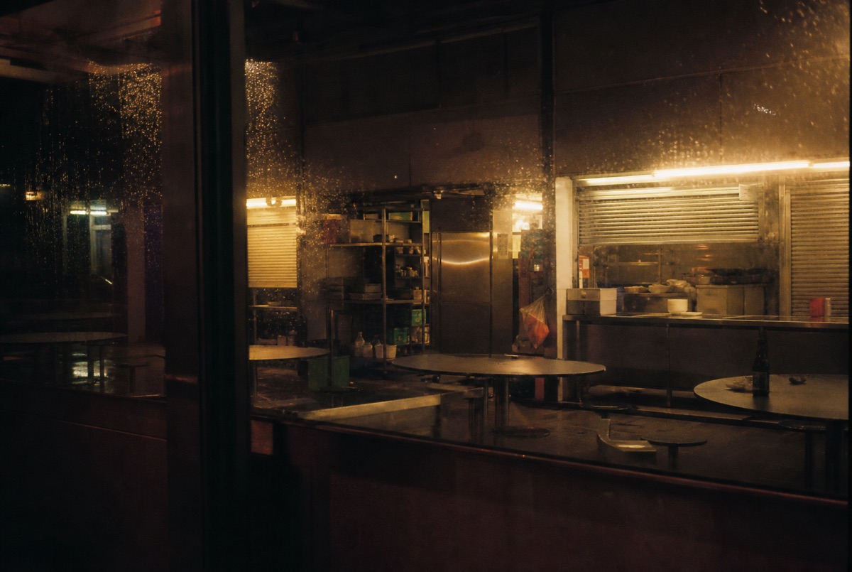 Warmly lit interior seen through rain-speckled glass